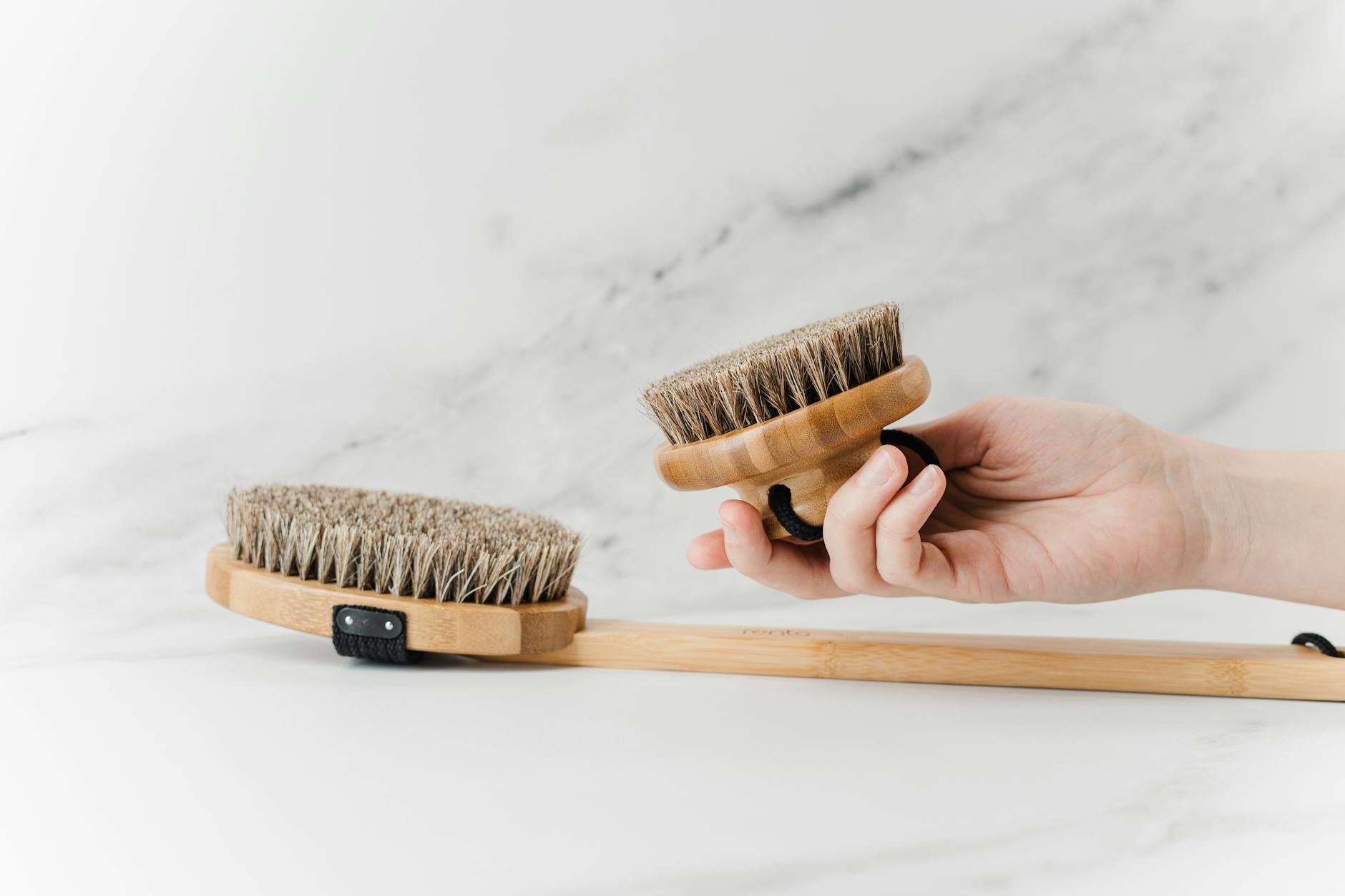 person holding brown wooden brush