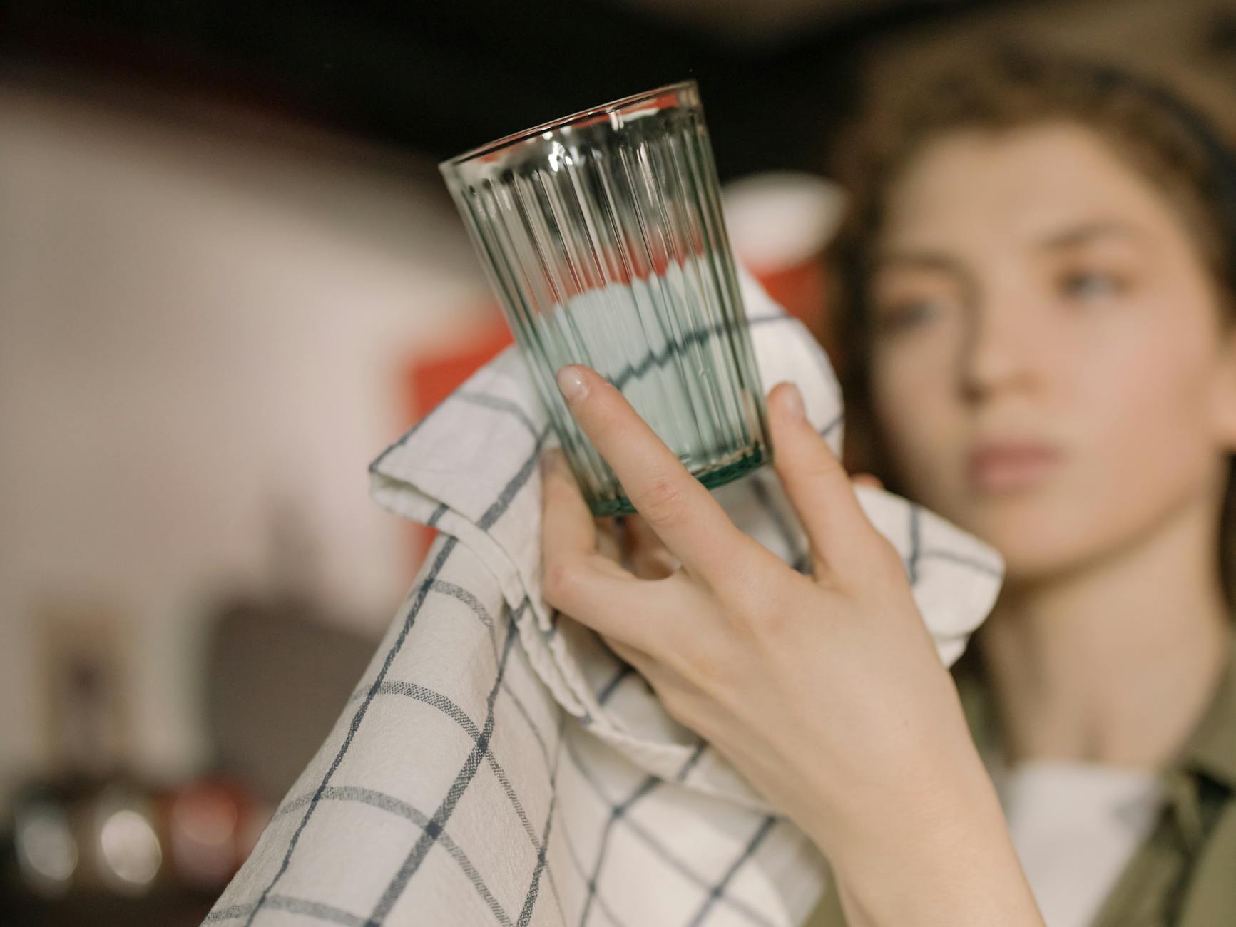 man in white and black checkered dress shirt holding drinking glass